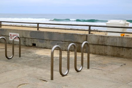 Public stainless steel wave shaped bike racks waiting for visitors near Pacific beach in early morning hours, San Diego, California