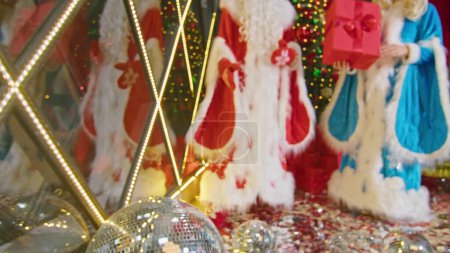 Téléchargez les photos : Père Noël et Mme Père Noël souhaitent joyeux Noël, donner des cadeaux et décorer l'arbre - en image libre de droit