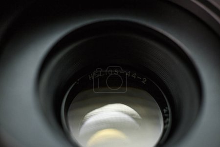 Mirando a través de una lente de cámara Helios 44-2, grabado marca en el borde interior, destacando los sutiles reflejos y contornos del interior de la lente