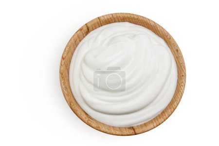 Téléchargez les photos : Crème sure ou yaourt dans un bol en bois isolé sur fond blanc avec pleine profondeur de champ. Vue de dessus. Pose plate. - en image libre de droit