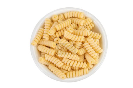 Italian spiral shaped pasta, Fusilli bucati macaroni in ceramic bowl, isolated on white background. Top view. Flat lay
