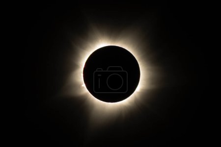 Photo for View of the moon moving in front of the sun, plunging the sky into darkness as only a few sunrays escape. Ningaloo Exmouth 2023 TSE, lasting for only a minute. Red prominences of the sun visible - Royalty Free Image