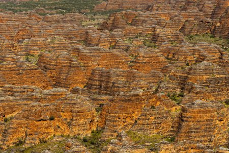From the air, giant rocky domes rise abruptly from dusty savannah plains, appearing like beehives, striped with cyanobacteria. This is perhaps Australias most striking and surreal landscape.