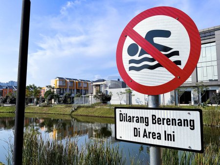 Do not swim sign near a lake in Indonesian language
