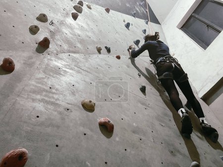 Junge Frau beim Indoor-Klettern, Flachbild-Aufnahme