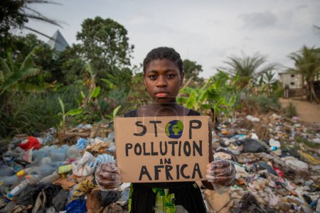 Photo for Young black african girl holding a sign written: stop pollution in Africa. - Royalty Free Image