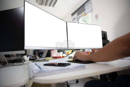 Foto de Dos pantallas en una oficina con fondo blanco. Escritorio de burlas en la oficina - Imagen libre de derechos