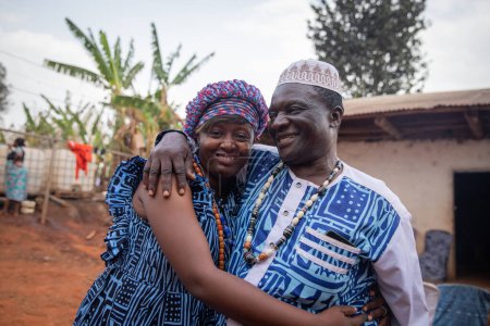 Téléchargez les photos : Two African people wearing traditional clothes hug each other during a celebration at the village - en image libre de droit