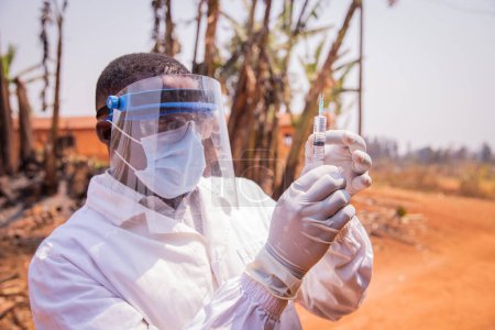 Foto de Un médico en África comprueba la jeringa de la vacuna - Imagen libre de derechos