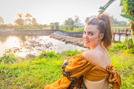 Portrait of a Caucasian girl wearing African clothing sitting in a park in Malabo