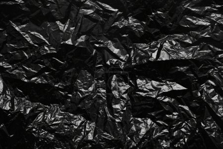 Téléchargez les photos : Plastique froissé sac en polyéthylène noir texture fond - en image libre de droit