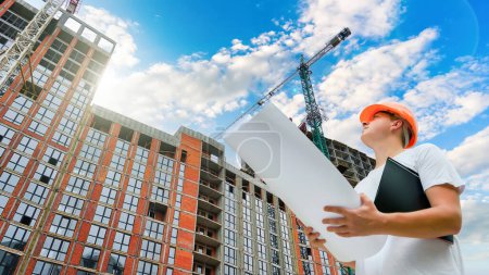 Ingeniero constructor de mirar en la construcción de un edificio residencial de varios pisos. Trabajos en obra