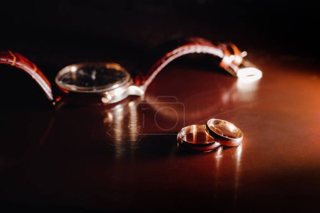 Téléchargez les photos : Golden wedding rings with wristwatch in the background - en image libre de droit