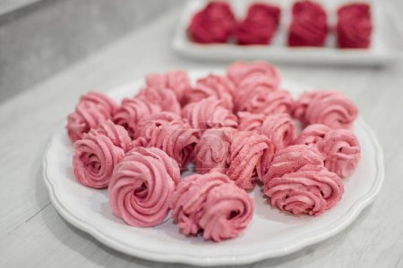 Foto de Muchos malvaviscos rojos y rosados cocidos yacen en el plato - Imagen libre de derechos