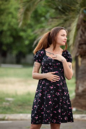 Foto de Bastante embarazada mujer delgada retrato en el vestido en una naturaleza - Imagen libre de derechos