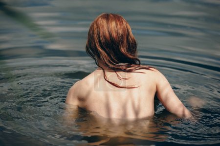 Photo for Back of naked woman swimming in the lake or river - Royalty Free Image