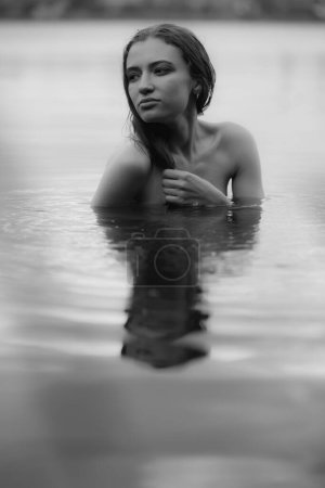 Foto de Retrato en blanco y negro de una mujer desnuda nadando en el lago - Imagen libre de derechos