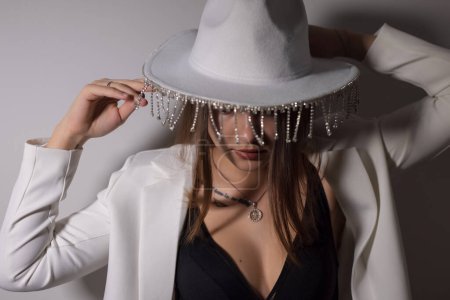 Photo for Stylish woman in a white hat with bright jewelry - Royalty Free Image