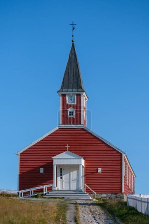 Foto de Pintada de rojo con adornos blancos, la Iglesia de Nuestro Salvador de Nuuk brilla contra un cielo azul claro. Groenlandia - Imagen libre de derechos