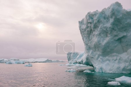 Téléchargez les photos : A collection of massive icebergs from the Icefjord in Illulisat, Groenland. Image tirée d'un petit bateau. - en image libre de droit