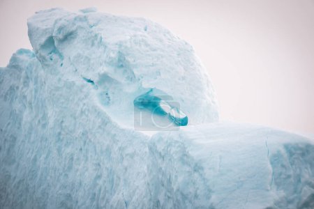 Téléchargez les photos : Un des icebergs massifs dans le Icefjord à Illulisat, Groenland, montrant de la neige blanche et turquoise texturée et deux yeux. - en image libre de droit