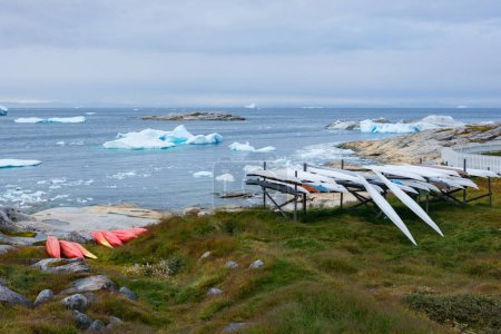 Téléchargez les photos : Près d'une mer avec des icebergs et bergy bit assis de nombreux kayaks. Certains sont de style traditionnel inuit - longs et étroits. Illulisat, Groenland. - en image libre de droit