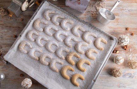 Fresh baked christmas cookies on silver colored baking tray. Vanillekipferl. Flat lay