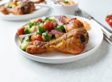 Low-Carb-Abendessen mit gebackenem Huhn, mariniertem Salat und Paprika-Feta-Dip auf einem Teller