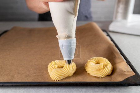 Photo for Piping choux pastry with a piping bag for making crullers - Royalty Free Image
