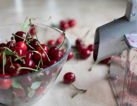 Photo for Pitting or coring cherries with a cherry pitter - Royalty Free Image