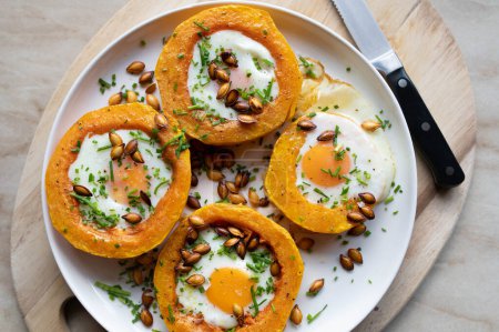 Photo for Gluten free vegetarian meal with oven roasted butternut squash,, eggs and pumkin seeds on a plate. Zero waste food - Royalty Free Image