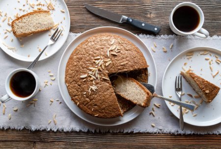 Gluten free sponge cake with almonds and coffee on a wooden background. Top view
