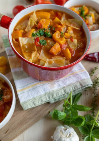 Téléchargez les photos : Soupe de légumes maison au chou dans une casserole rustique sur une table - en image libre de droit