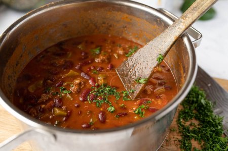 Soupe saine de haricots faibles en gras dans une casserole. Cuites avec haricots rouges, boeuf haché maigre, légumes tels que tomates, piment, poivrons, oignons, ail et herbes