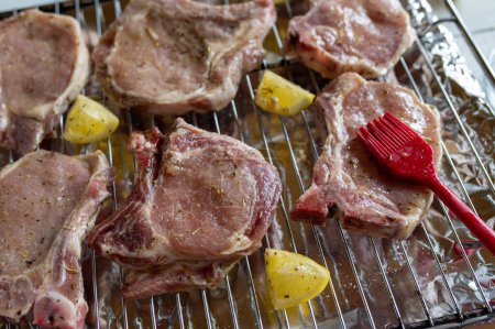 Raw and fresh marinated pork chops on a oven rack