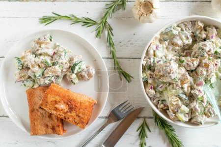 Téléchargez les photos : Filet de saumon poêlé avec salade de pommes de terre grecque sur fond de bois blanc d'en haut - en image libre de droit