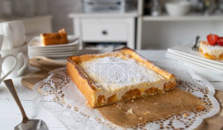 Délicieux gâteau au fromage fait maison avec des abricots sur une table. Fraîchement cuit. Servi entier et tranché avec vue en coupe transversale. Prêt à manger.
