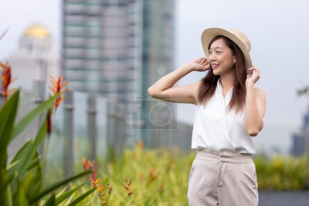 Photo for Asian woman tourist enjoying her rooftop panoramic view with cityscape background for vacation and travel - Royalty Free Image