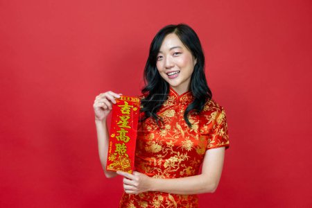 Téléchargez les photos : Femme asiatique tenant fortune rouge bénédiction mot chinois qui signifie "être béni par une étoile chanceuse" isolé sur fond rouge pour le concept de célébration du Nouvel An chinois - en image libre de droit