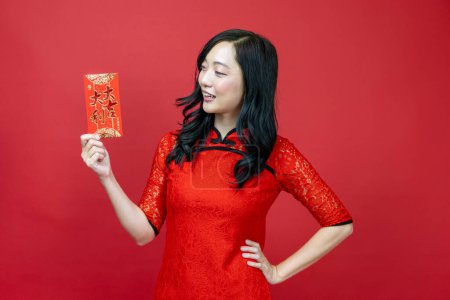 Photo for Asian woman holding red money fortune envelope blessing Chinese word which means "May you have great luck and great profit" isolated on red background for Chinese New Year celebration - Royalty Free Image