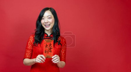 Téléchargez les photos : Asian woman holding red money fortune envelope blessing Chinese word which means "May you have great luck and great profit" isolated on red background for Chinese New Year celebration - en image libre de droit