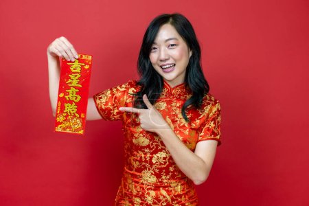 Téléchargez les photos : Femme asiatique tenant fortune rouge bénissant mot chinois qui signifie "être béni par une étoile chanceuse" isolé sur fond rouge pour la célébration du Nouvel An chinois - en image libre de droit