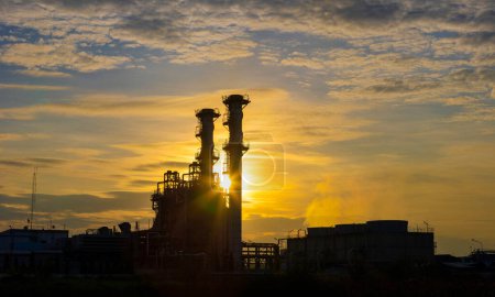 Téléchargez les photos : Silhouette of gas turbine power plant at sunset which create pollution and global warming cause ozone layer depletion for electricity and energy - en image libre de droit