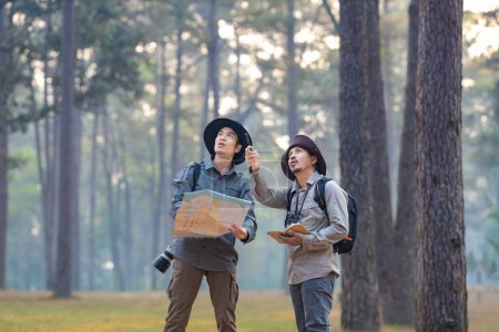 Foto de Equipo del naturalista asiático mirando el mapa mientras explora en el bosque de pinos para estudiar y descubrir la rara diversidad biológica y ecologista en el concepto de estudio de campo - Imagen libre de derechos