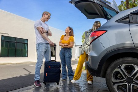 Photo for Caucasian family is fitting their luggage in the trunk after renting a car at the airport terminal for weekend vacation travel concept - Royalty Free Image