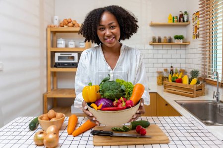 Photo for African American housewife is showing variety of organic vegetables to prepare simple and easy cajun southern style salad meal for vegan and vegetarian soul food - Royalty Free Image