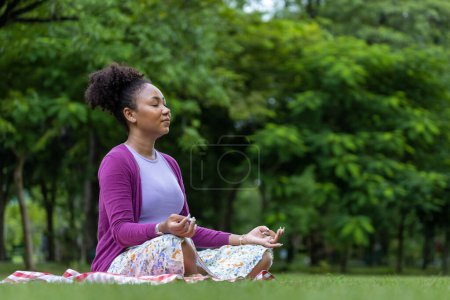 Téléchargez les photos : African American woman relaxingly practicing meditation in the forest to attain happiness from inner peace wisdom for healthy mind and soul - en image libre de droit