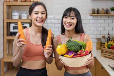 Photo for Asian sister is having a healthy food and drink while helping each other cooking in kitchen for vegan, vegetarian and plant based ingredient - Royalty Free Image