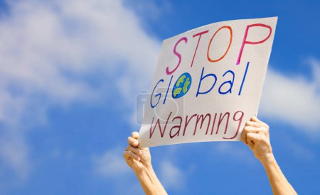 Photo for Hand of volunteer activist holding stop global warming sign during the protest against pollution and climate change to reduce carbon footprint concept - Royalty Free Image