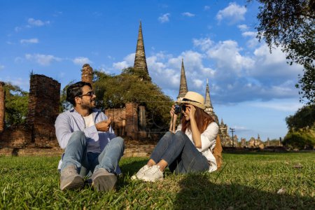 Téléchargez les photos : Couple de touristes étrangers utilisent l'appareil photo pour prendre des photos au temple Wat Phra Si Sanphet, Ayutthaya Thaïlande, pour Voyage, vacances, vacances, lune de miel et le tourisme - en image libre de droit